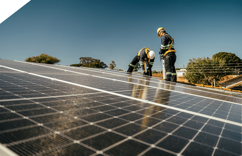 Workers installing solar panels on roof.