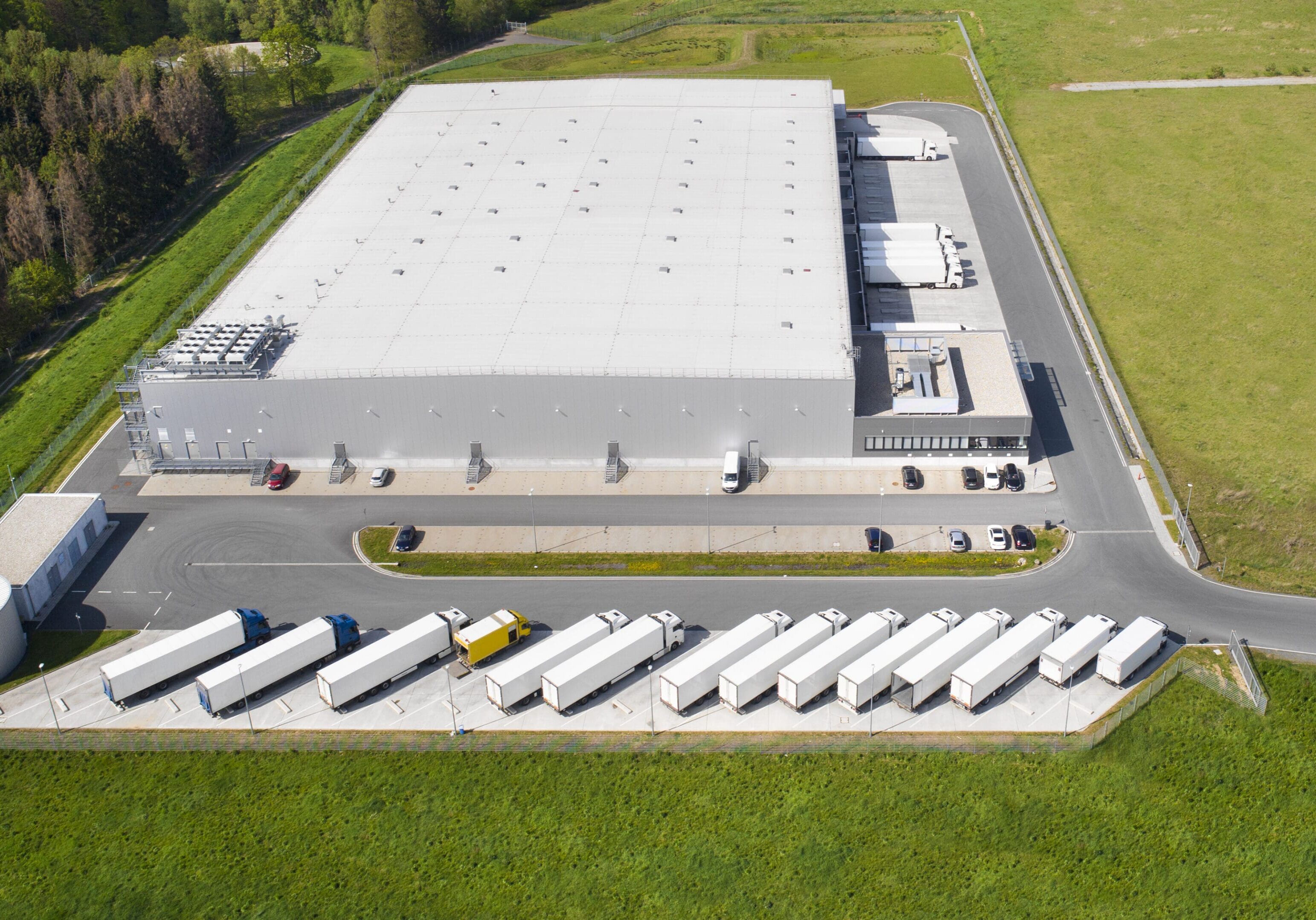 Loading bay, truck parking lot, industrial building, logistics - aerial view